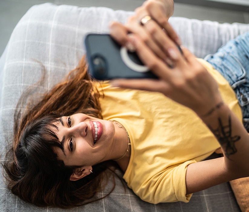 Eine Frau recherchiert mit ihrem Handy, wie sie persönliche Daten aus dem Internet entfernen kann.